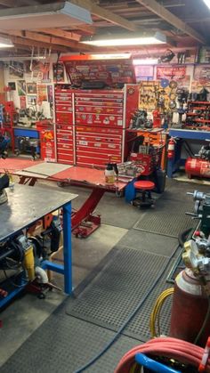 the inside of a garage with tools and other items on tables, including fire extinguishers