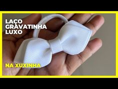 a hand holding a white bow tie in it's left hand with the words lacco cravatinha luxo next to it