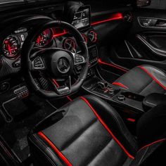 the interior of a sports car with black leather and red stitching on the dash