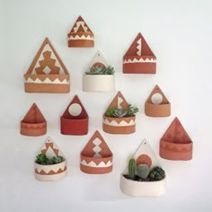 a group of clay houses with succulents and cacti