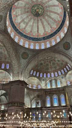 the interior of an ornate building with chandeliers hanging from it's ceiling