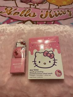 the hello kitty book is laying on a pink blanket next to it's packaging