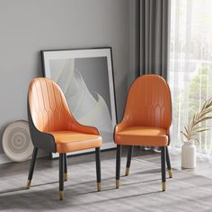 two orange chairs sitting next to each other in front of a window