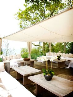 an outdoor living area with couches and tables