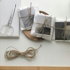 some white boxes tied up with twine on a wooden plate and cutting knife next to them