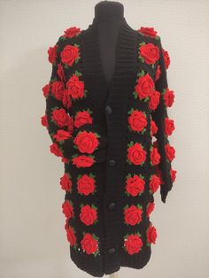 a black cardigan with red roses on it