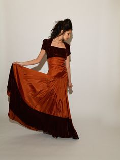 Burgundy velvet contrasts with shimmering red-orange taffeta in this one-of-a-kind dress just made for twirling! Featuring a square neckline bust and short sleeves made of velvet, the lightly ruched taffeta bodice nips your middle before falling to an ultra-low drop-waist. The heavy skirt swings full all the way to the floor, her sweep trimmed with matching velvet! Truly a rare and special find! Layaway is available! ~ S I Z I N G ~ * Best approximates: Extra-Extra Small to Extra Small, or 00-0 * Bust: 32" * Natural waist: 24" * Drop waist/hip: 34" * Length from shoulder to hem: 61" * Length from drop waist to floor: 36" * Sleeve length: 7" * Skirt sweep: 288" (144" across, doubled for circumference) Measurements are snug! We recommend measuring out a similar piece of clothing that fits yo Match Velvet, Burgundy Velvet, Floor Length Dresses, Square Necklines, Drop Waist, Burgundy Red, Dress Clothes For Women, Square Neckline, Piece Of Clothing