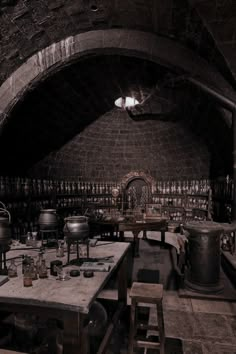 an old fashioned kitchen with many pots and pans on the table in black and white