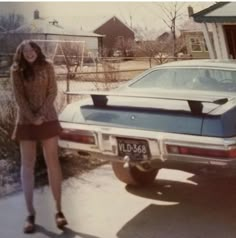 a woman standing next to a parked car