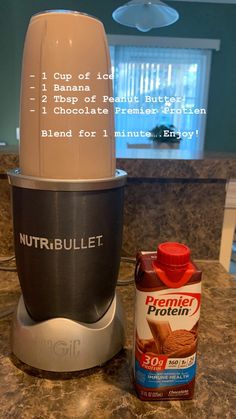 a blender sitting on top of a counter next to a bottle of nut butter