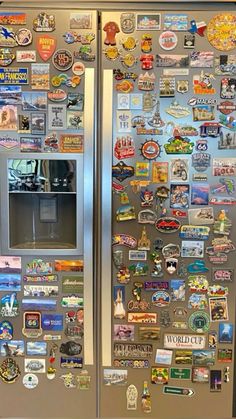 a stainless steel refrigerator covered in magnets and stickers