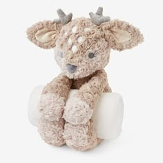 a small stuffed animal with horns on it's head is sitting in front of a white background