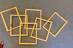 a pile of wooden frames sitting on top of a gray table next to a red pen