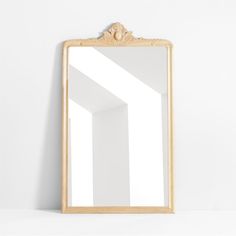 a mirror sitting on top of a white wall