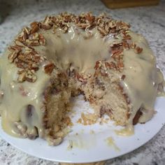 a bundt cake covered in frosting and pecans