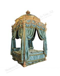 an ornate canopy bed with gold trimmings and blue drapes on the sides