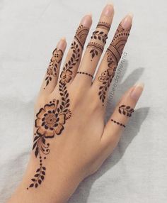 a woman's hand with henna tattoos on it