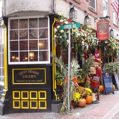 a store front with flowers and plants on the side of it's street corner