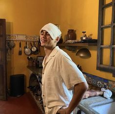 a man with a bandage on his head standing in a kitchen