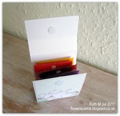 a stack of cards sitting on top of a wooden table next to a white wall