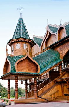 an ornate wooden building with green roofing