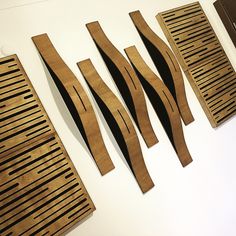 four pieces of wood sitting on top of a white table next to grates and spatulas