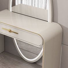 a white dressing table with a mirror on it's top and gold trim around the edge