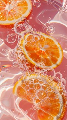 three oranges with bubbles in the water