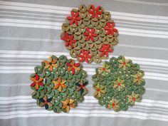 three pieces of paper are arranged in the shape of flowers on a striped tablecloth