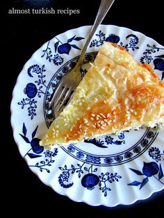 a piece of pie on a blue and white plate with a fork next to it