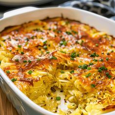 a casserole dish with cheese and vegetables in it on a wooden table top