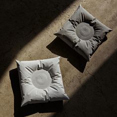 two pillows sitting on the ground next to each other