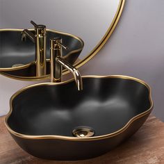 two sinks in front of a mirror on top of a wooden table with a faucet