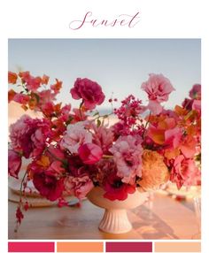 a vase filled with lots of pink flowers on top of a table next to plates