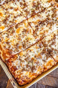 a square pizza sitting on top of a pan covered in cheese and meat toppings