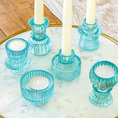 blue glass candle holders on a marble tray