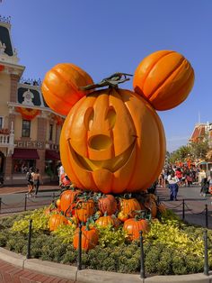 a mickey mouse pumpkin statue in the middle of a street