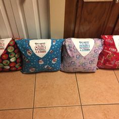 four colorful bags sitting on the floor in front of a door with words written on them