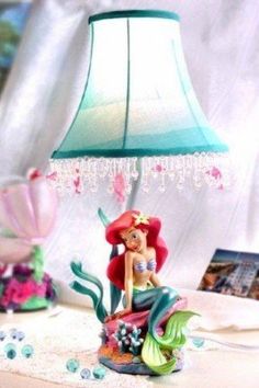 a little mermaid lamp sitting on top of a table