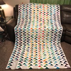 a large quilt on the floor next to a couch