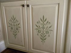 an old cabinet painted with green flowers and leaves on the doors is shown in this image