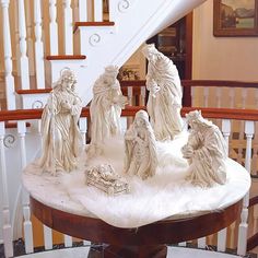 a group of statues sitting on top of a table in front of a banister