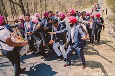 a group of men in turbans are dancing on the side of a road