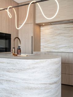 a modern kitchen with marble counter tops and lights