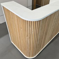 the counter is made out of wood and has a curved top with white trim on it