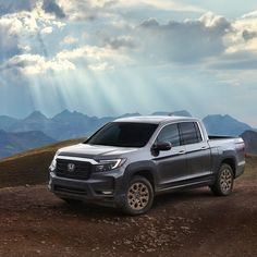 a silver truck parked on top of a dirt road