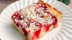 a piece of cake on a white plate with crumbs and powdered sugar