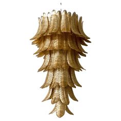 a chandelier hanging from the ceiling with gold leaves on it's sides