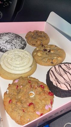 a pink box filled with different types of cookies