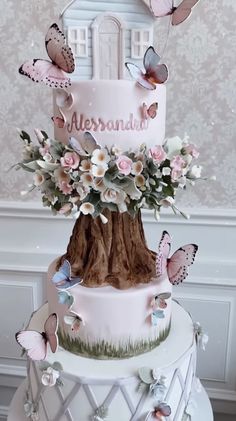 a three tiered cake decorated with butterflies and flowers